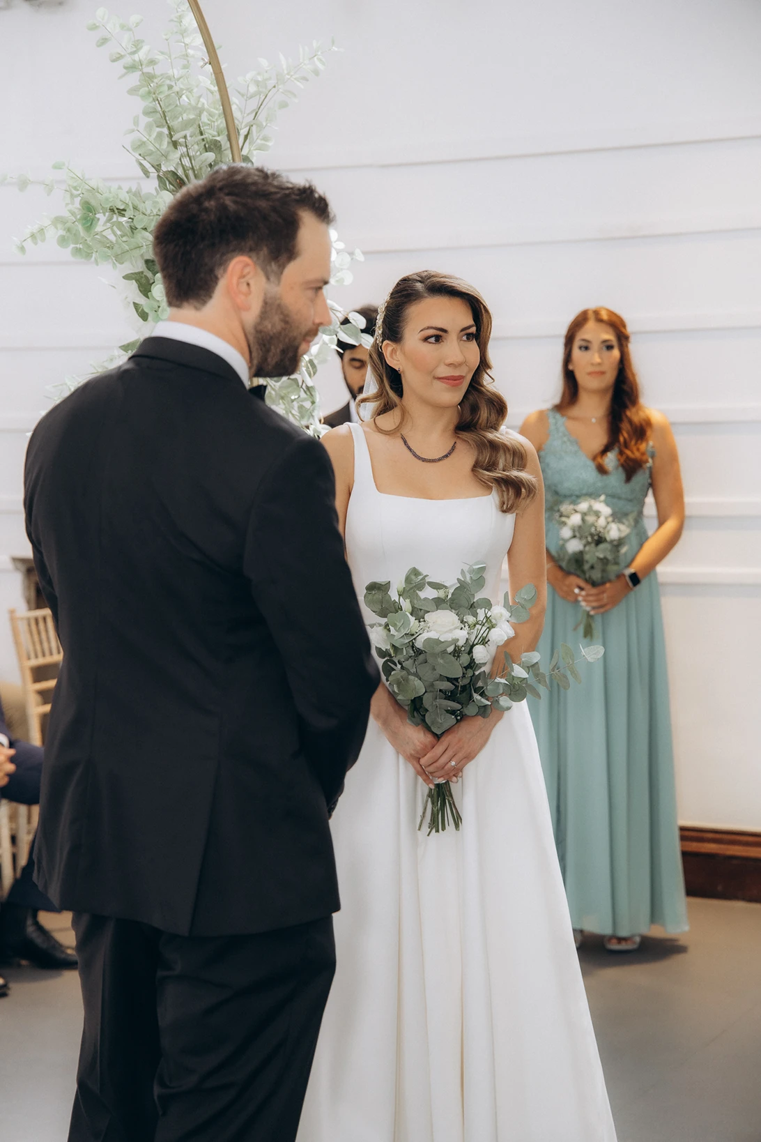 Bride holding a bouquet, standing with the groom during the ceremony at Fulham Library Wedding.