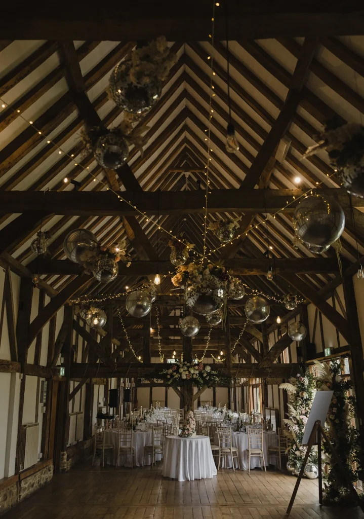 Loseley Park wedding reception with string lights and rustic barn décor