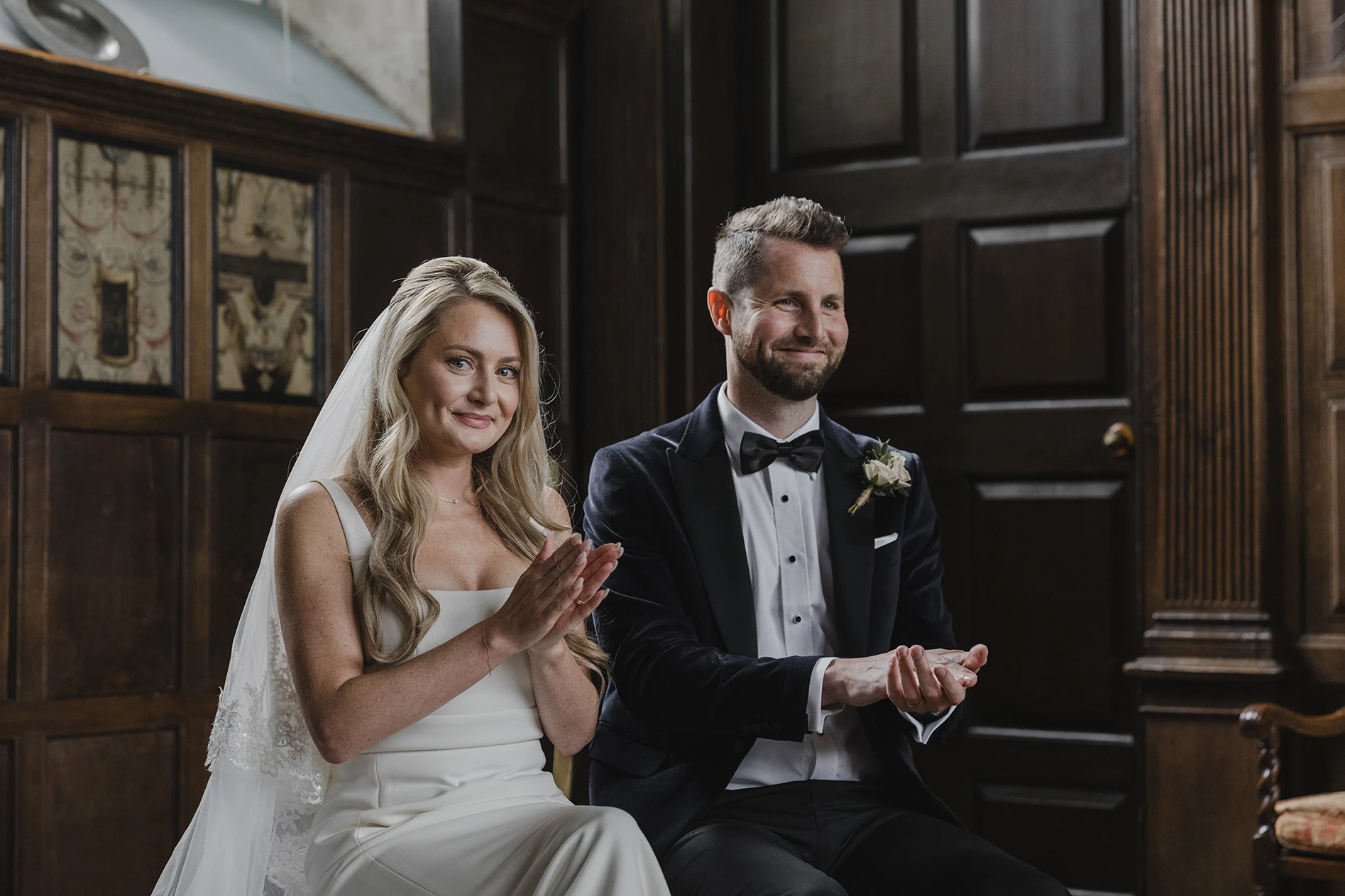 Bride and groom applauding at their Loseley Park wedding