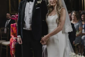 Bride and groom holding hands during Loseley Park wedding ceremony