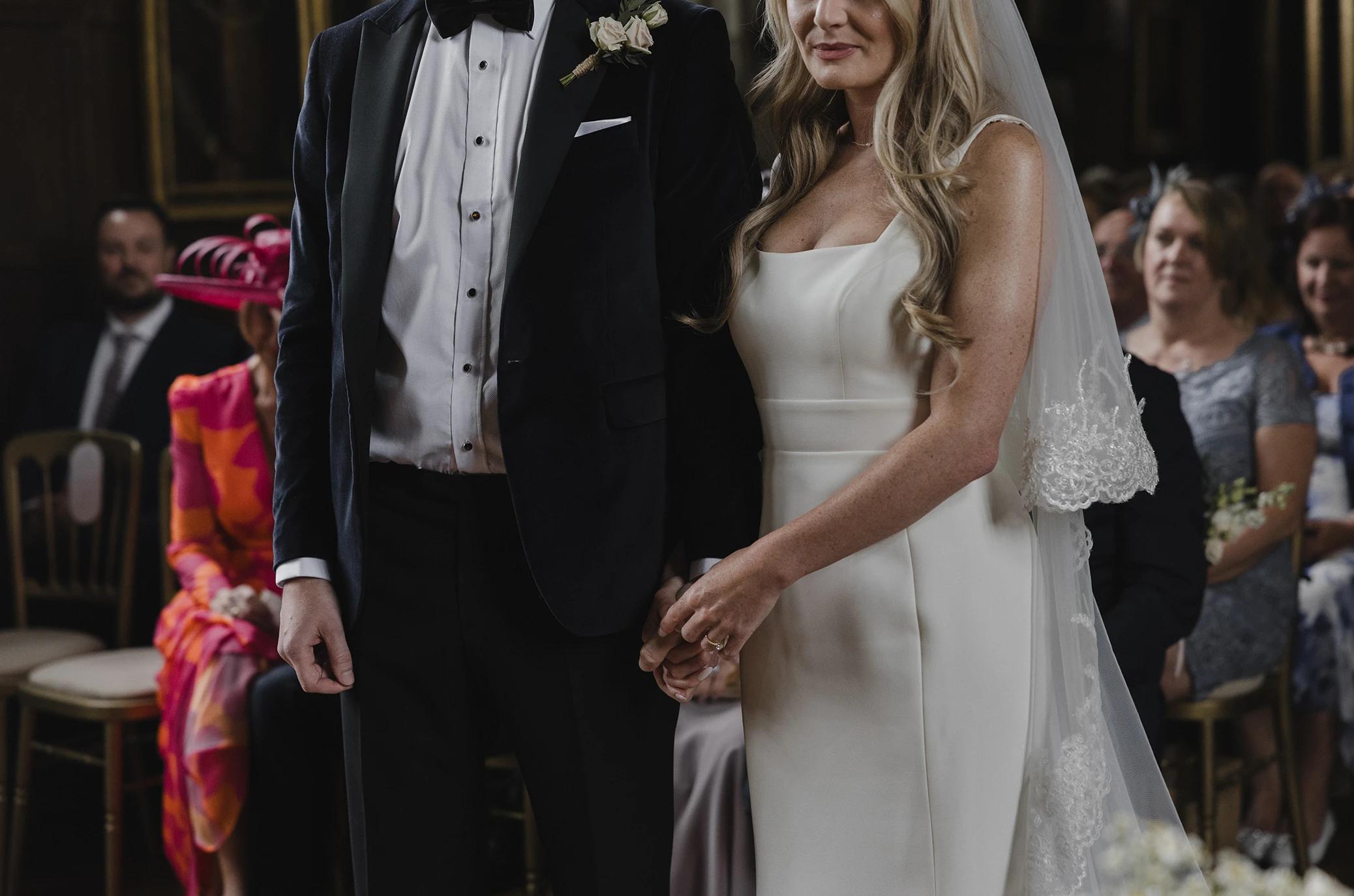 Bride and groom holding hands during Loseley Park wedding ceremony