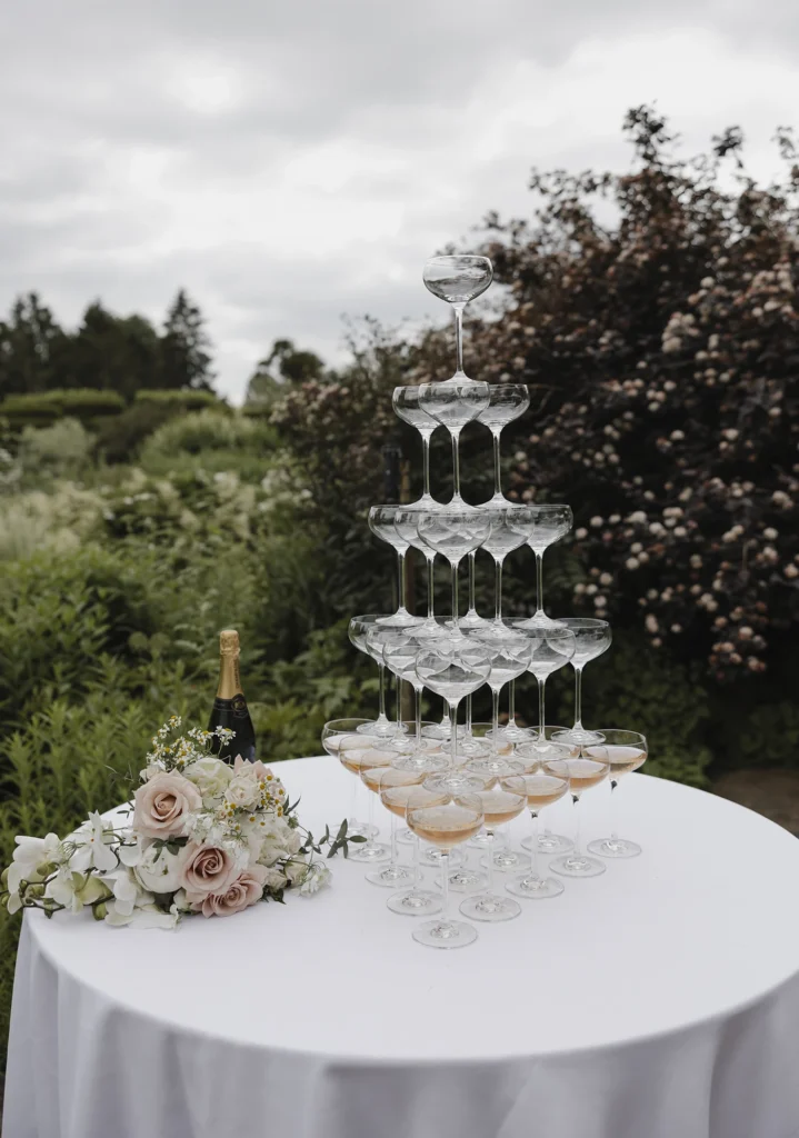 Champagne tower with floral arrangements at Loseley Park wedding reception.