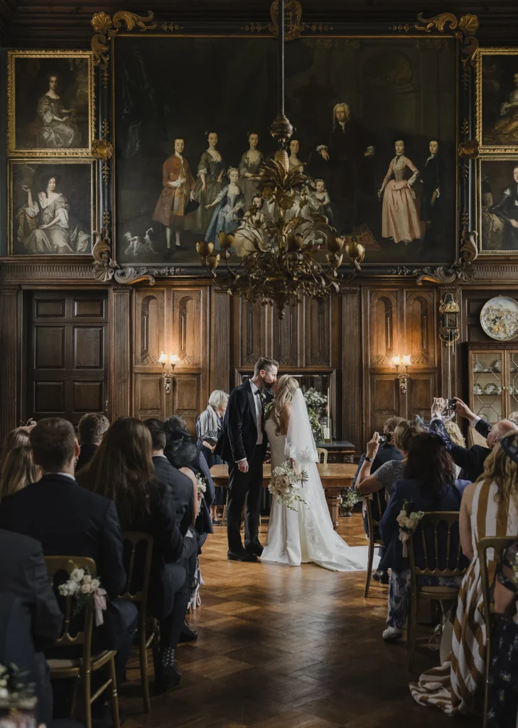 Bride and groom sharing their first kiss at Loseley Park wedding