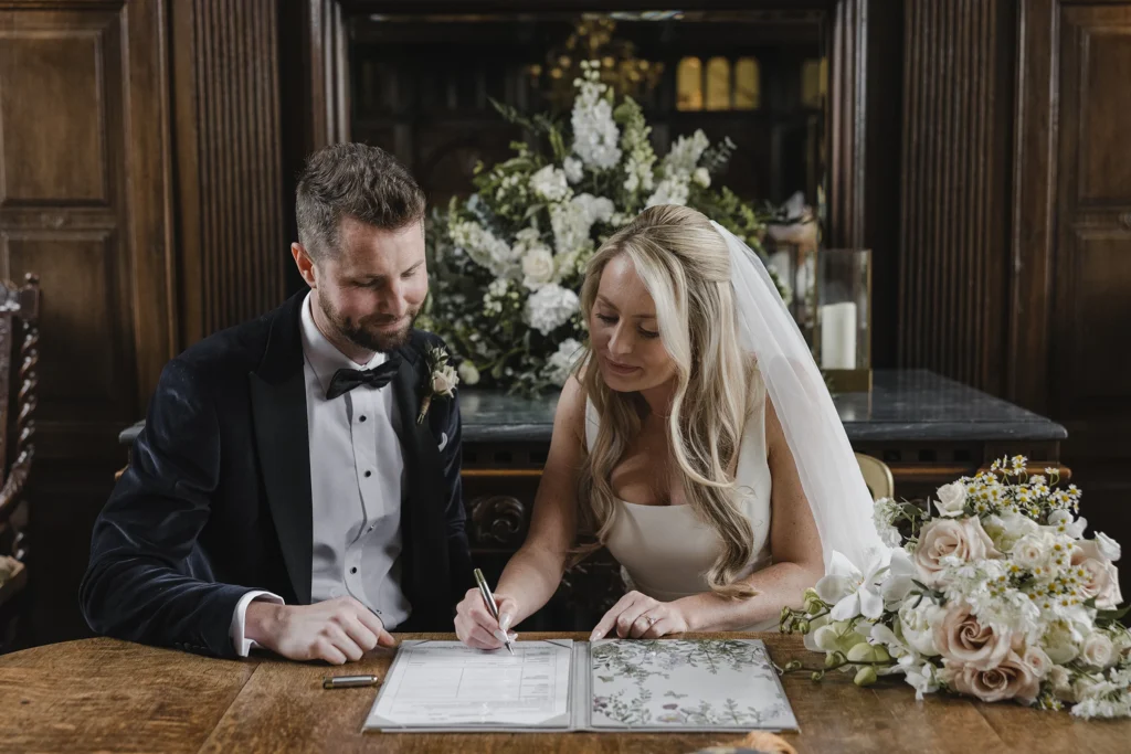 Bride signing the wedding registry at Loseley Park