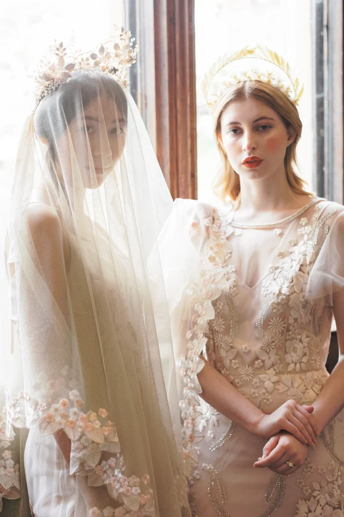 Two brides showcasing intricate veils and floral headpieces at Nutfield Priory wedding venue.