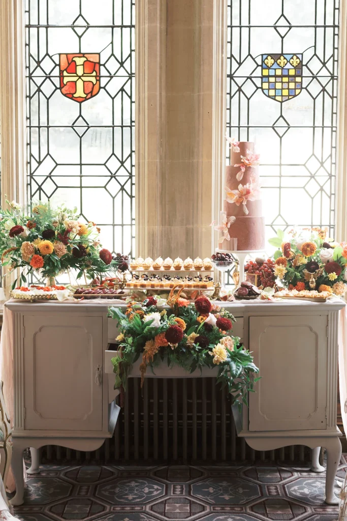 Ornate dessert table featuring a multi-tier wedding cake and floral arrangements at Nutfield Priory.