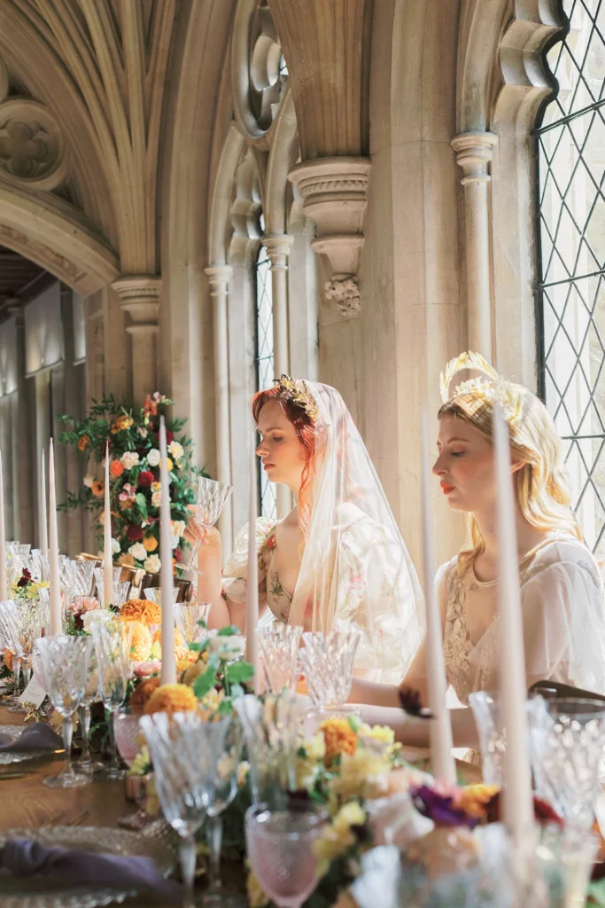 Brides seated at an elegant dining table adorned with floral decor in Nutfield Priory’s grand hall.