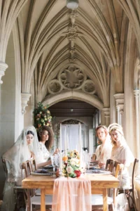 Group of brides in stunning wedding attire seated at a decorated dining table in Nutfield Priory.