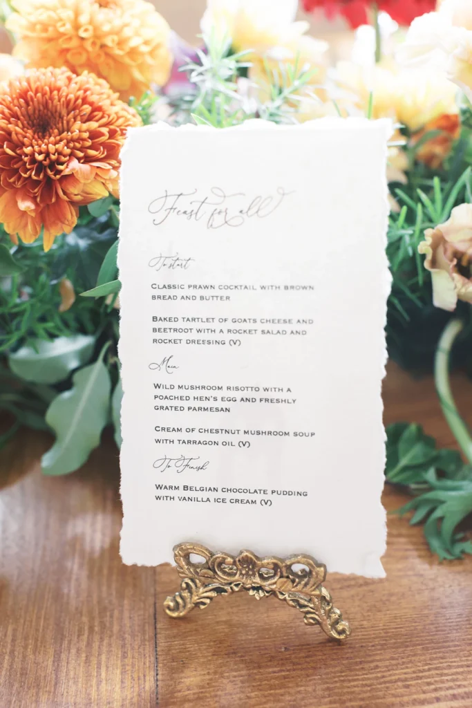 Wedding menu design with floral backdrop featuring Nutfield Priory-inspired dishes.