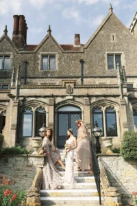 Group of brides in unique wedding dresses posing outside Nutfield Priory.