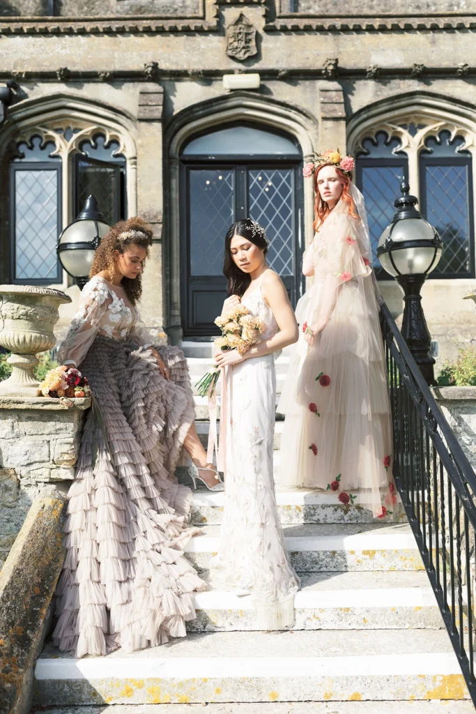 Close-up of brides in elegant gowns and veils on the Nutfield Priory staircase.