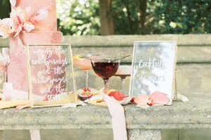 Wedding cocktail bar setup featuring creative signage and floral accents.