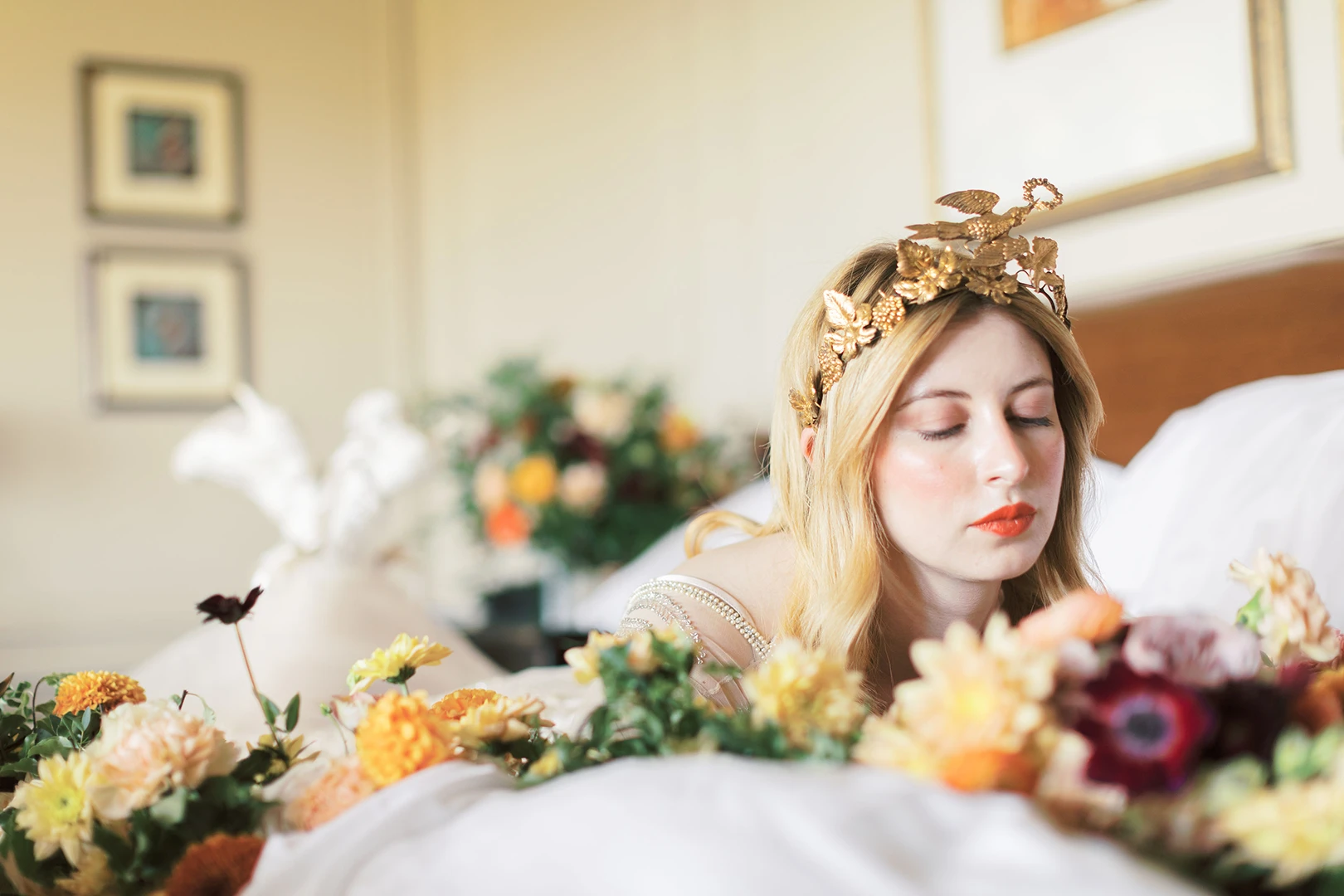 Bride with a golden crown lying amidst colorful flowers during a bridal photoshoot at Nutfield Priory.