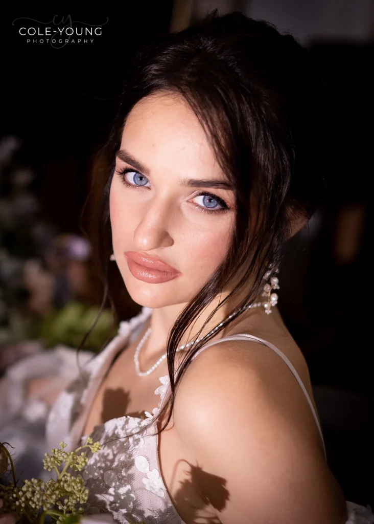 Close-up of bride's glowing makeup and pearl earrings at Pelham House.