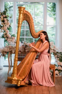 Harpist performing at a wedding ceremony with romantic floral arrangements at Pelham House.