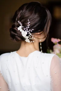 Intricate bridal hairstyle adorned with white floral accessories, captured during Pelham House photoshoot.