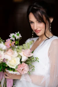 Bride holding a pastel floral bouquet, smiling softly, captured at Pelham House wedding photoshoot.