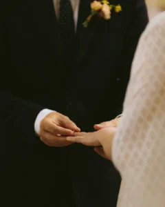 Close-up of the groom placing the wedding ring on the bride's finger during their minimalist London wedding.