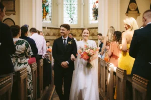 Bride and groom walking down the aisle together after their minimalist wedding ceremony in London.