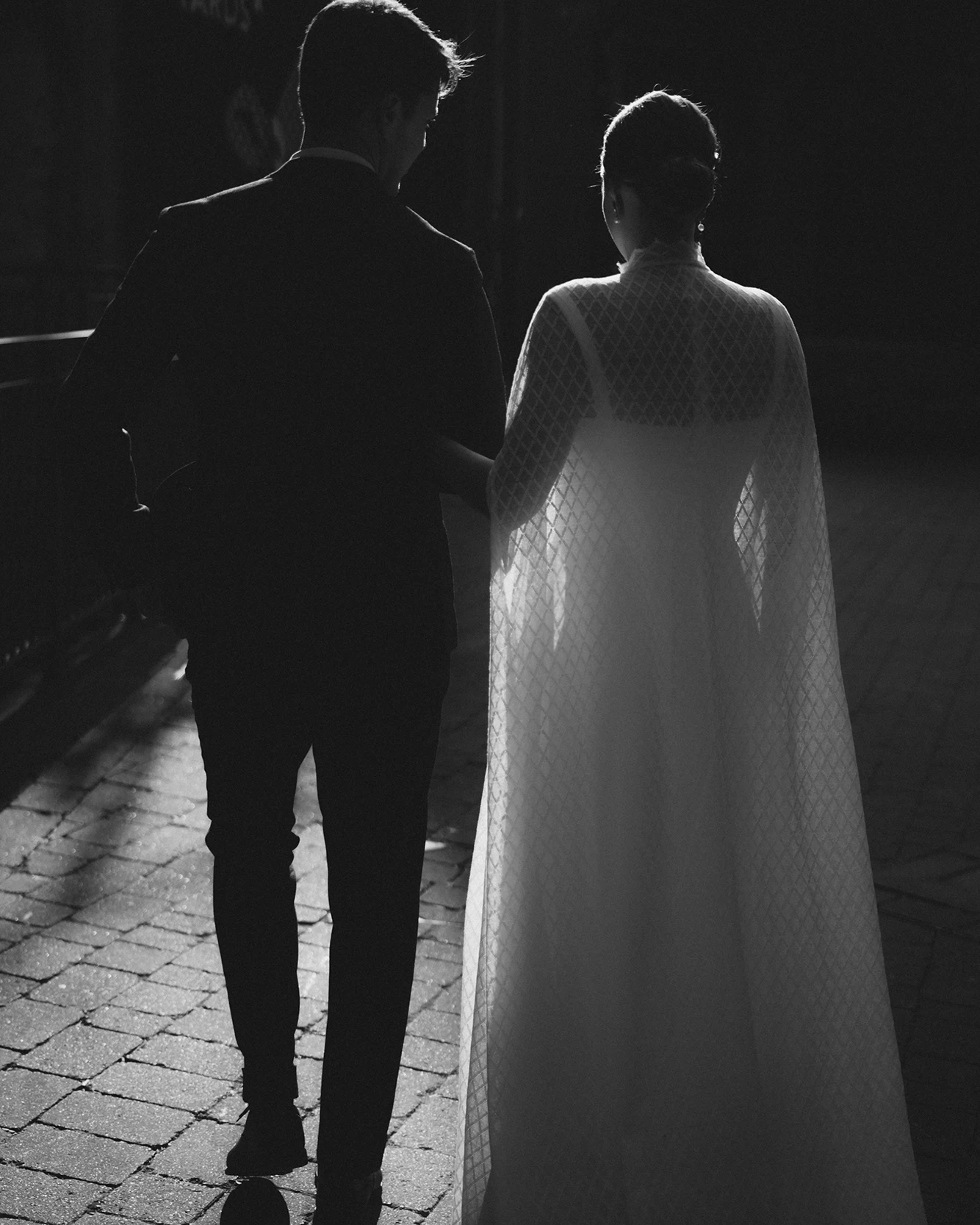 Silhouette of the bride and groom walking together in the evening after their minimalist wedding in London.