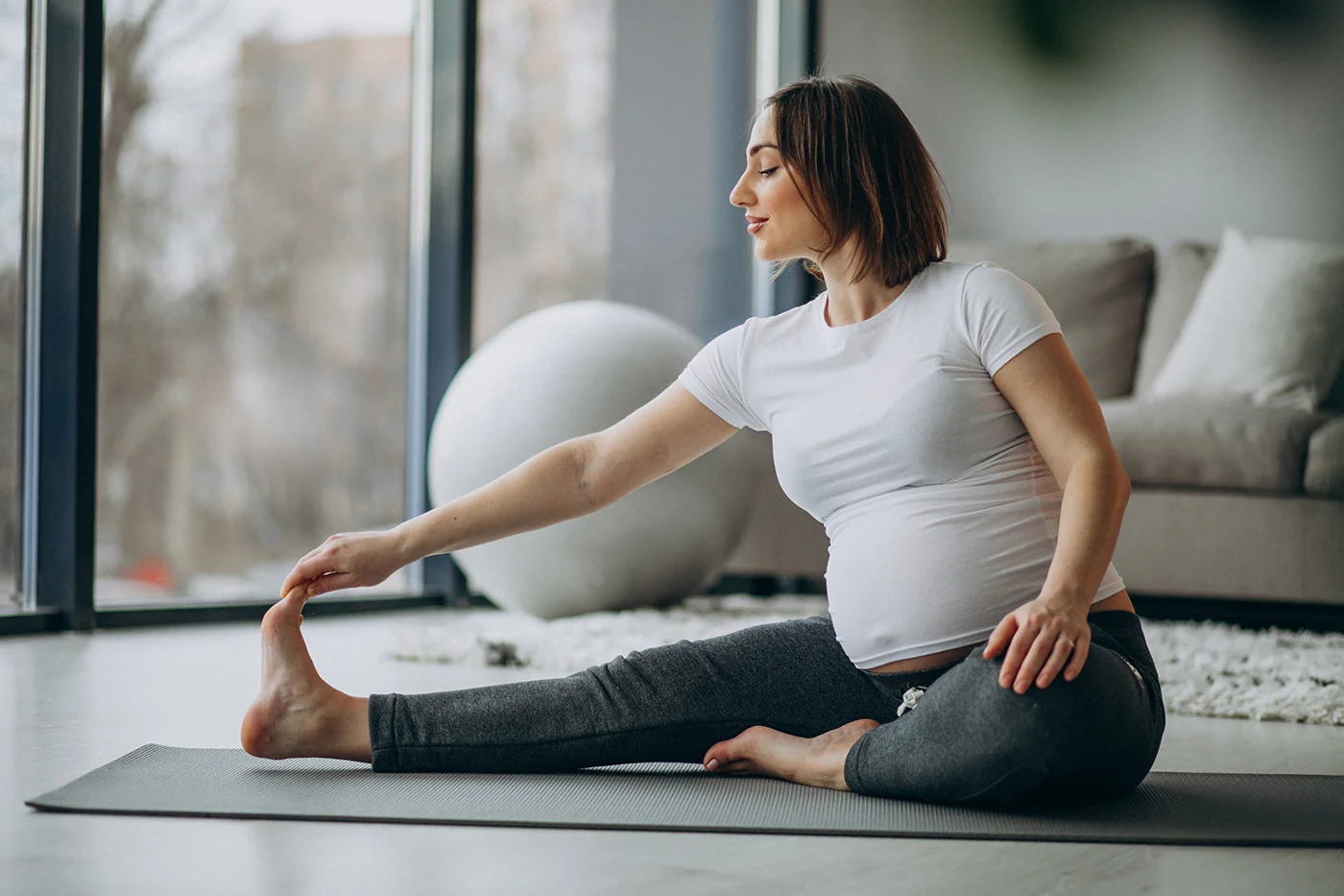 Pregnant woman practising yoga at home.