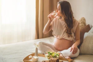 Pregnant woman eating a healthy meal and drinking water