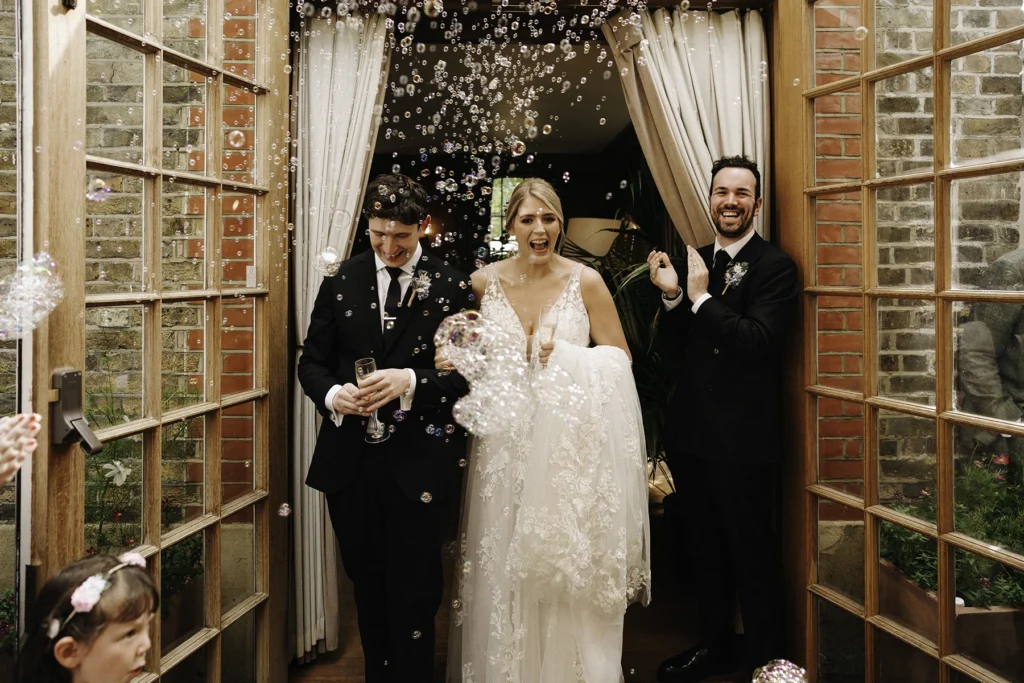 Bride and groom walking through bubbles after ceremony