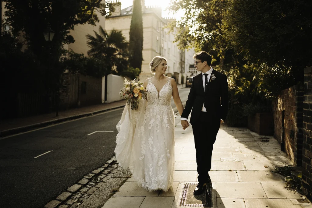 Bride and groom walking hand in hand down a Hampstead street