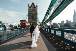 Bride and groom walking across Tower Bridge