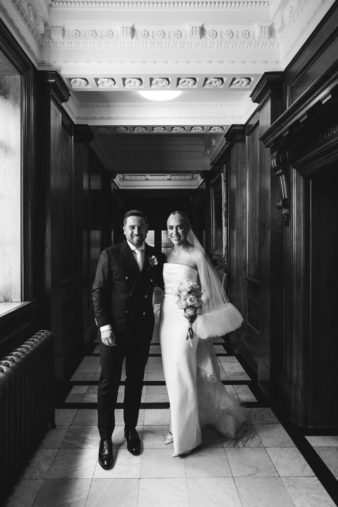 Bride and groom standing in a beautiful hallway of a city venue