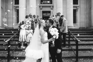 Bride and groom share a kiss under a confetti shower