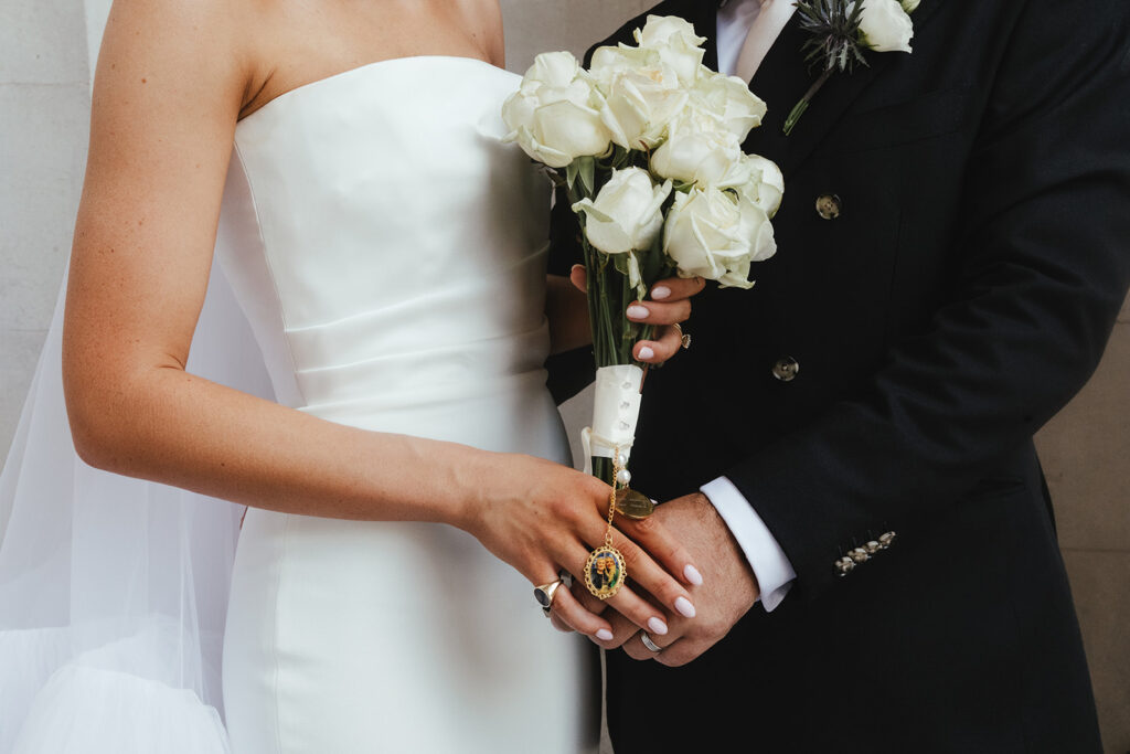 Bride holding a bouquet of white roses at a city chic wedding