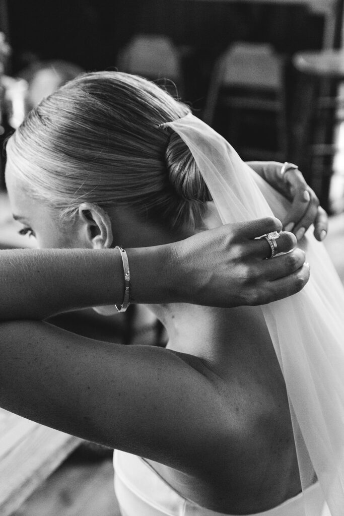 Close-up of bride adjusting her veil