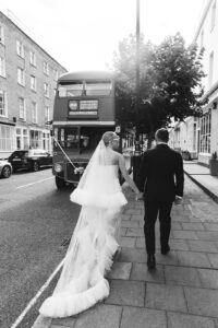 Bride and groom walking to a London wedding bus