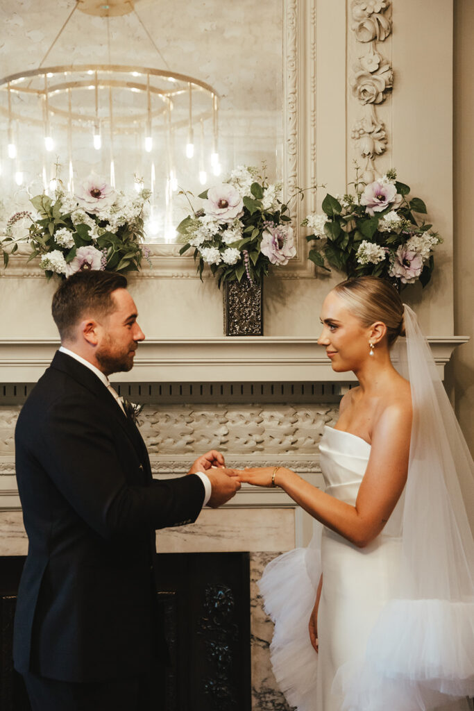 Groom placing the wedding ring on the bride’s finger during the ceremony