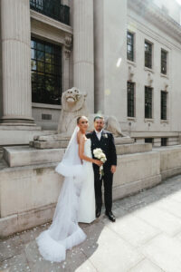 Newlyweds posing outside wedding venue