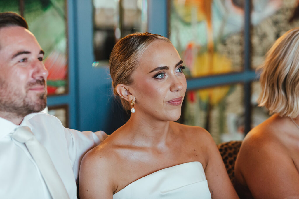 Bride getting emotional while listening to a heartfelt speech at the reception