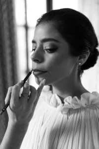 Makeup artist applying soft, natural lipstick as she completes her bridal beauty routine for her elegant wedding