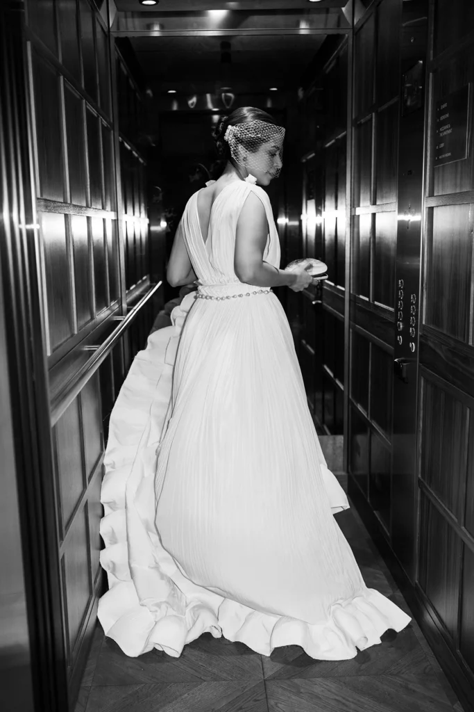 Black and white shot of bride in an elegant wedding dress in an elevator