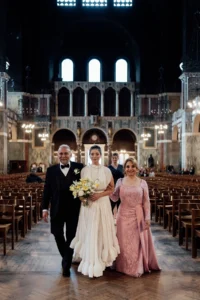 Bride walking down the aisle with both parents in a stunning cathedral