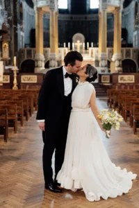 Bride and groom share a kiss in front of a breathtaking cathedral altar