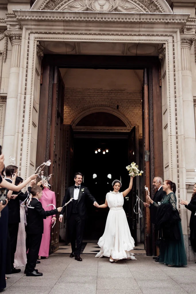 Bride and groom celebrating their wedding exit surrounded by cheering guests