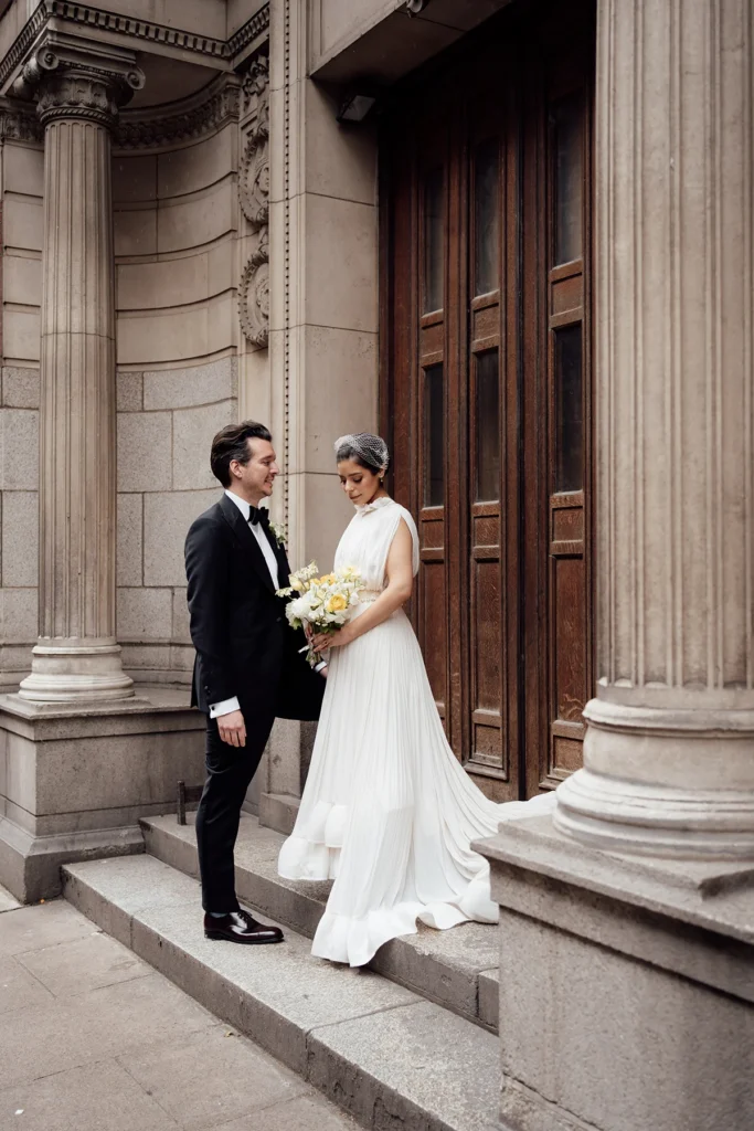 Bride and groom in front of classic architectural columns