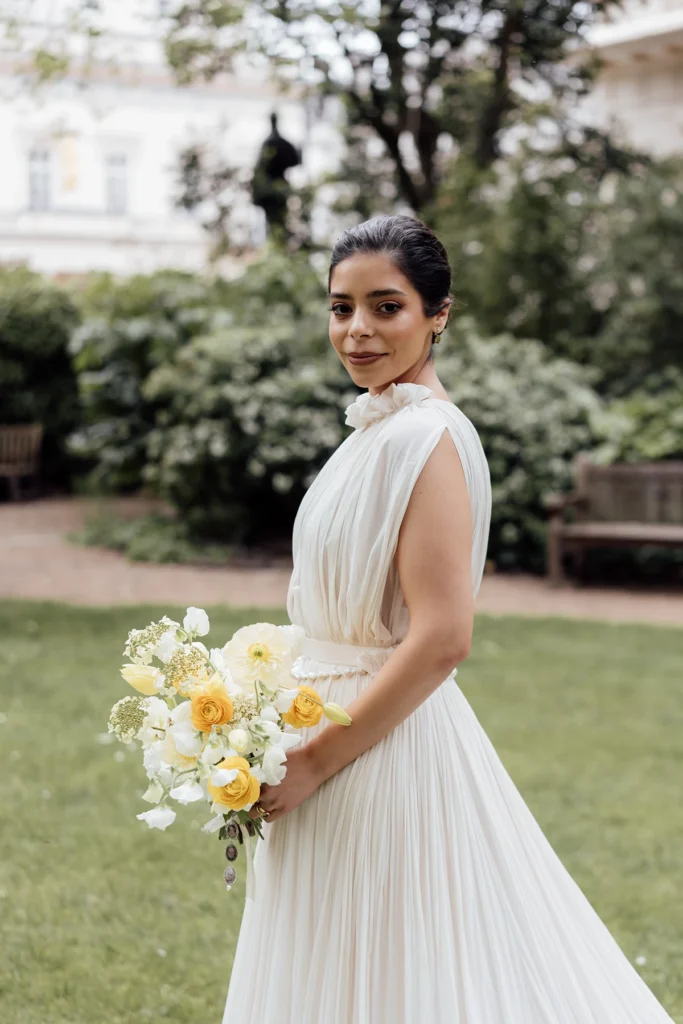 Elegant bride holding a bouquet in a lush garden