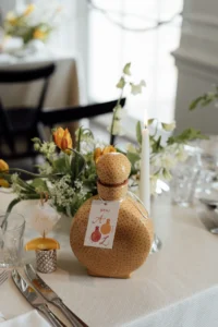 Elegant wedding table setting with tequila bottle and floral decor