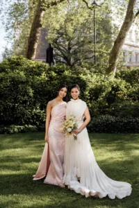 Bride and bridesmaid posing at an elegant wedding in a lush garden