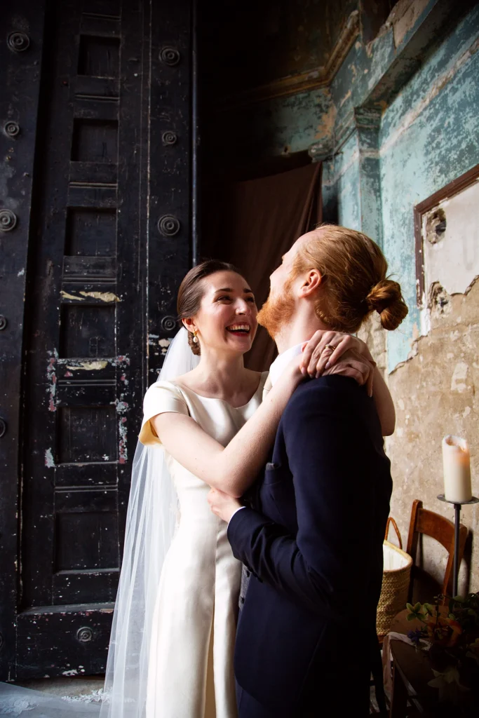 Bride and groom share a joyful moment at Asylum Chapel