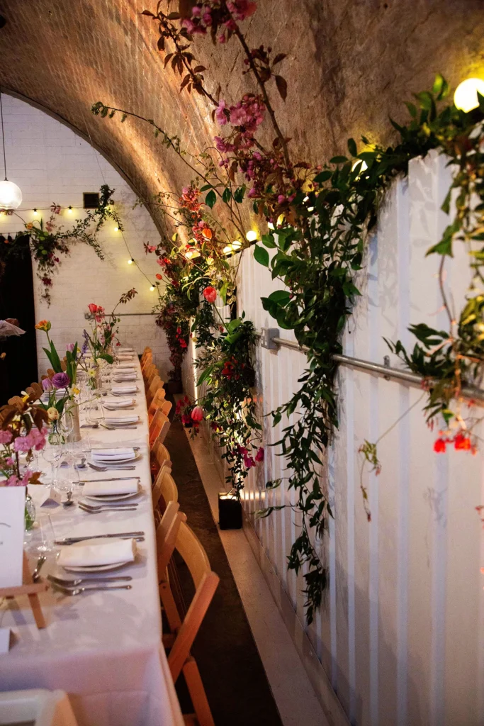 Romantic wedding dinner setup with floral arch and candlelight