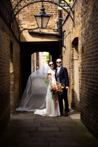Newlyweds posing in a charming brick alley after their Asylum Chapel wedding