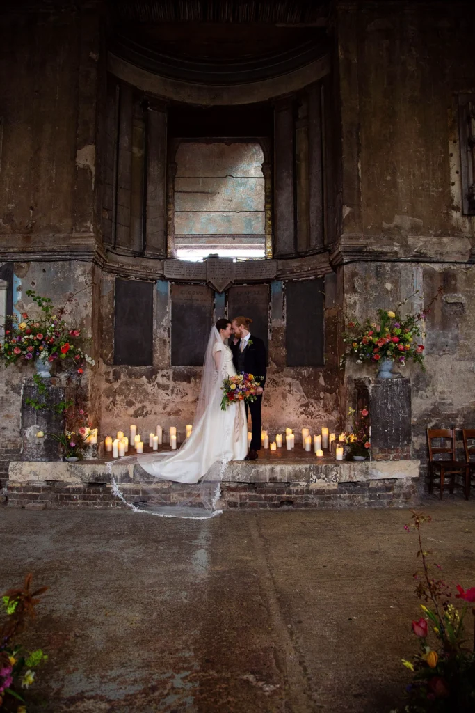 Newlyweds embracing under the historic altar of Asylum Chapel